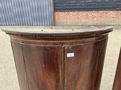 Lot 58 - Two George III mahogany bowfront corner cupboards