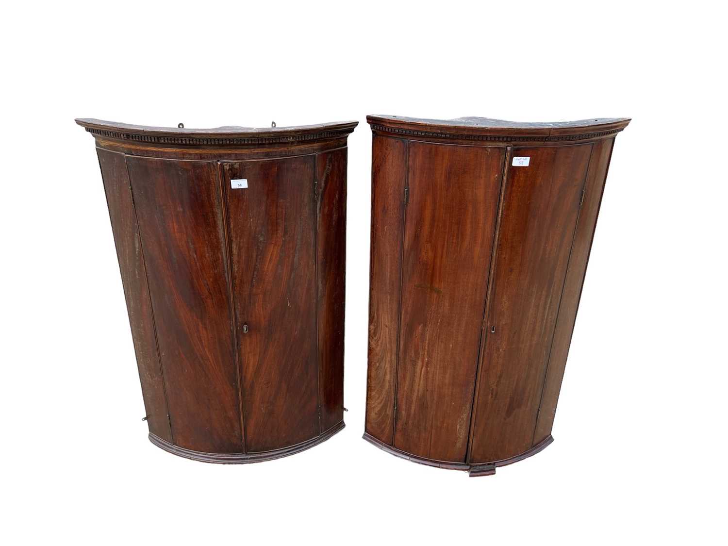 Lot 58 - Two George III mahogany bowfront corner cupboards