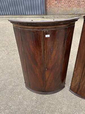 Lot 58 - Two George III mahogany bowfront corner cupboards