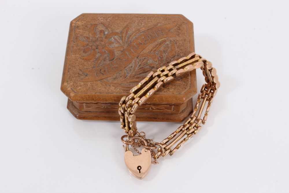 Lot 871 - 9ct rose gold gate bracelet with padlock clasp, within a small carved wood trinket box