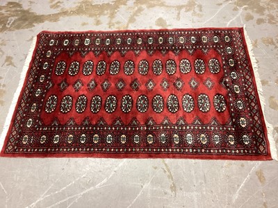 Lot 1138 - Three Eastern rugs with geometric decoration on red ground, 149cm x 96cm