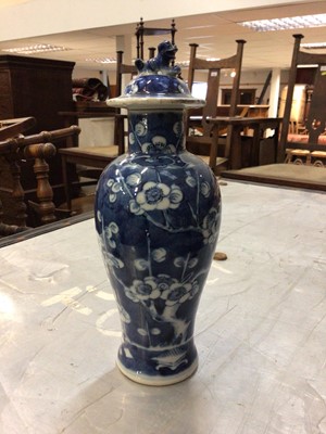 Lot 688 - A Chinese blue and white porcelain baluster vase and cover, circa 1900, decorated with prunus blossom and auscpicious symbols, 23cm high including cover