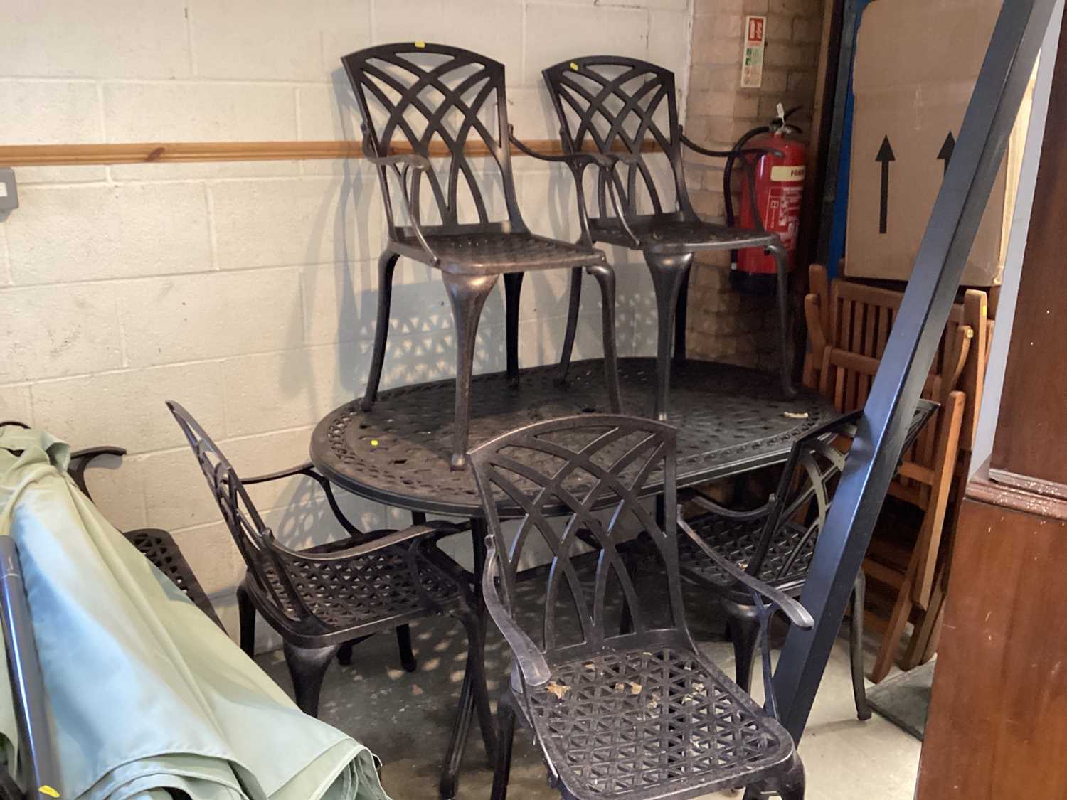 Lot 1165 - Aluminium garden set comprising oval table with parasol, six elbow chairs and a two seater bench