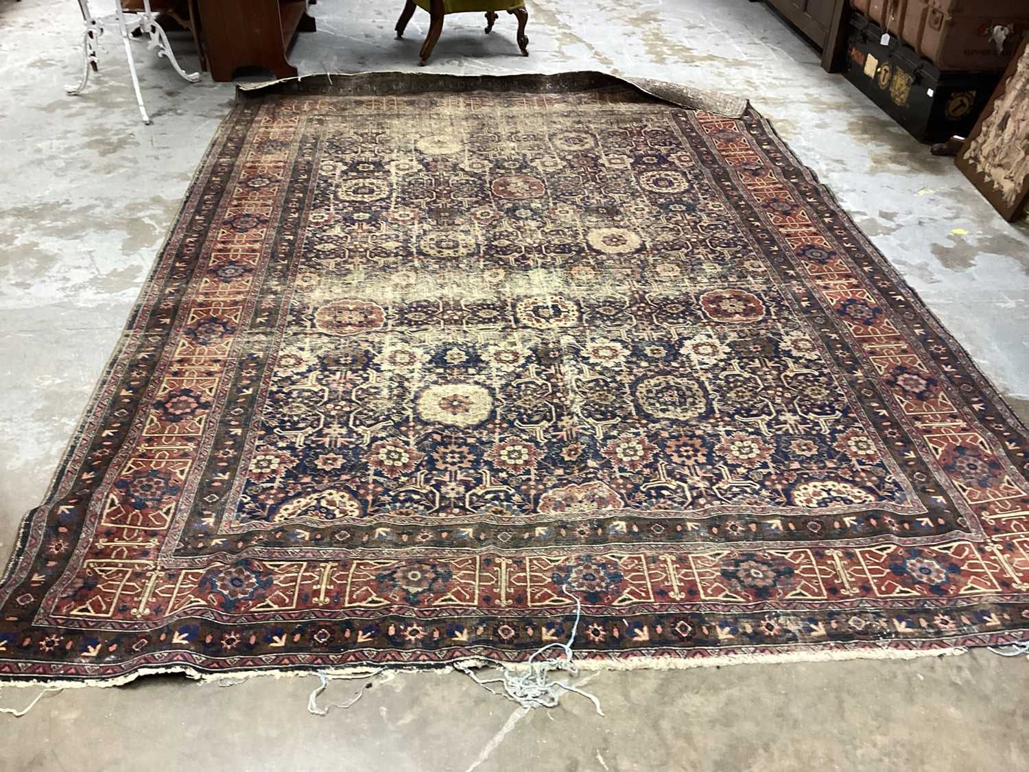 Lot 1216 - Large Eastern rug with geometric decoration on red and blue ground, 322cm x 230cm