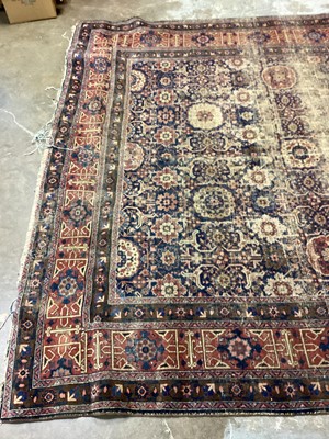 Lot 1216 - Large Eastern rug with geometric decoration on red and blue ground, 322cm x 230cm