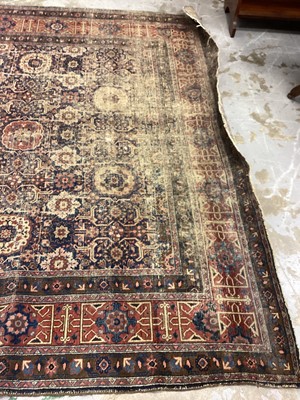 Lot 1216 - Large Eastern rug with geometric decoration on red and blue ground, 322cm x 230cm