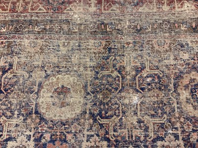 Lot 1216 - Large Eastern rug with geometric decoration on red and blue ground, 322cm x 230cm