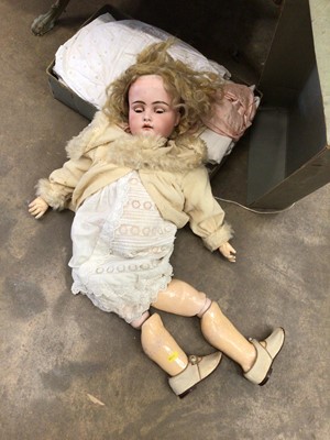 Lot 526 - A bisque head doll and a box of dolls clothes