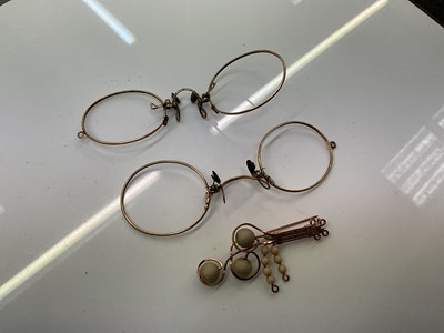 Lot 894 - Two pairs of yellow metal spectacle frames and a yellow metal brooch (3)