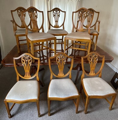 Lot 1230 - Georgian-style yew twin pedestal dining table with one extra leaf and eight matching chairs comprising six standards and a pair of carvers. Appears to have been supplied by Harrods