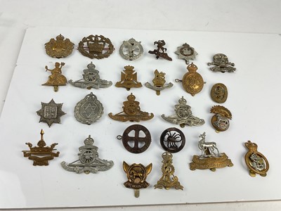Lot 450 - Collection of twenty five British military cap badges to include Norfolk Regiment, Royal Artillery Volunteers and 9th Lancers, a mixture of reproduction and original badges noted.