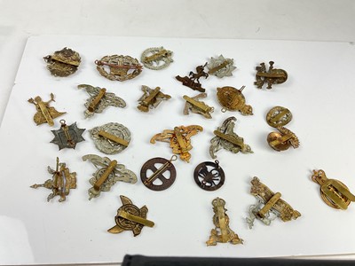 Lot 450 - Collection of twenty five British military cap badges to include Norfolk Regiment, Royal Artillery Volunteers and 9th Lancers, a mixture of reproduction and original badges noted.