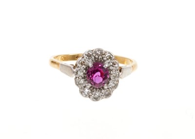 Lot 429 - Ruby and diamond cluster ring with an oval mixed cut ruby surrounded by a border of single cut diamonds in platinum setting on 18ct gold shank