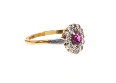 Lot 429 - Ruby and diamond cluster ring with an oval mixed cut ruby surrounded by a border of single cut diamonds in platinum setting on 18ct gold shank