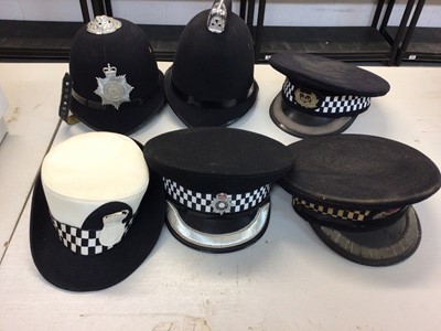 Lot 553 - Group of six Elizabeth II Police helmets and hats, some with embroidered badges (1 box)