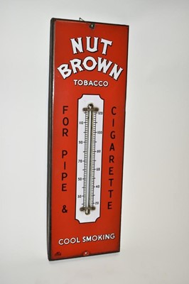 Lot 2409 - Nut Brown Tobacco enamel sign with thermometer on a red ground - 'For pipe & cigarette - cool smoking', 57.5cm x 19cm