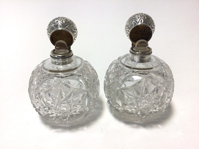 Lot 91 - A pair of Victorian silver mounted and cut glass scent bottles, of globular form, the tops relief-decorated