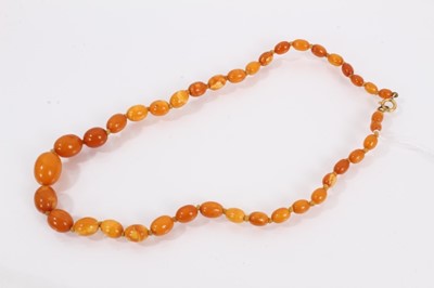Lot 827 - Butterscotch amber graduated bead necklace with oval polished beads, the largest measuring 15mm x 10mm and the smallest 6mm x 4mm, 44cm long