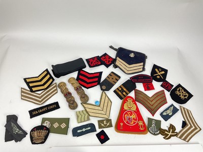 Lot 558 - Collection of cloth military badges, rank insignia and other items.