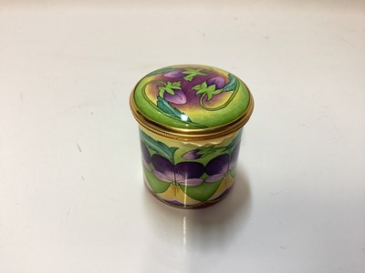 Lot 1245 - Moorcroft enamel trinket box decorated with purple flowers on green ground, in original box