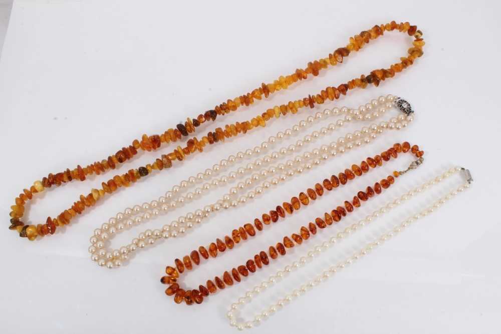 Lot 864 - Two amber bead necklaces, cultured pearl necklace with silver clasp and one other simulated pearl necklace (4)