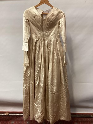 Lot 2117 - 1845 Victorian wedding dress in cream silk folded pleats on boned bodice with pointed waistline, two tier sleeves, detachable large bow to be worn at the waist, matching short cape silk cape trimme...