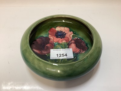 Lot 1254 - Moorcroft pottery circular shallow bowl decorated in the Anemone pattern on blue and green ground, impressed blue painted signature - Potter To H.M The Queen, 14cm diameter