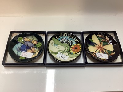 Lot 1255 - Three Moorcroft pottery M.C.C. pin dishes - Triple Choice, Panache and Lily Plume, all in original boxes