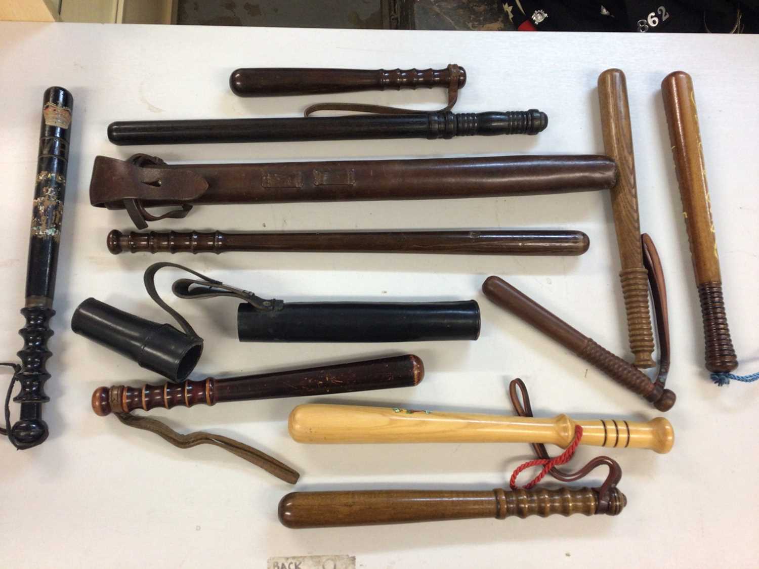 Lot 620 - Two mounted Police batons in leather sheaths