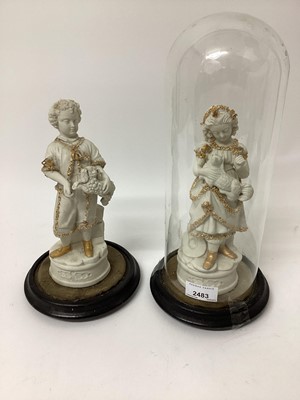 Lot 2483 - A pair of Victorian bisque figures on bases, one under an antique glass dome, 13" high including dome