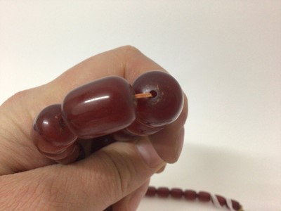 Lot 941 - Simulated cherry amber necklace with graduating polished oblong beads