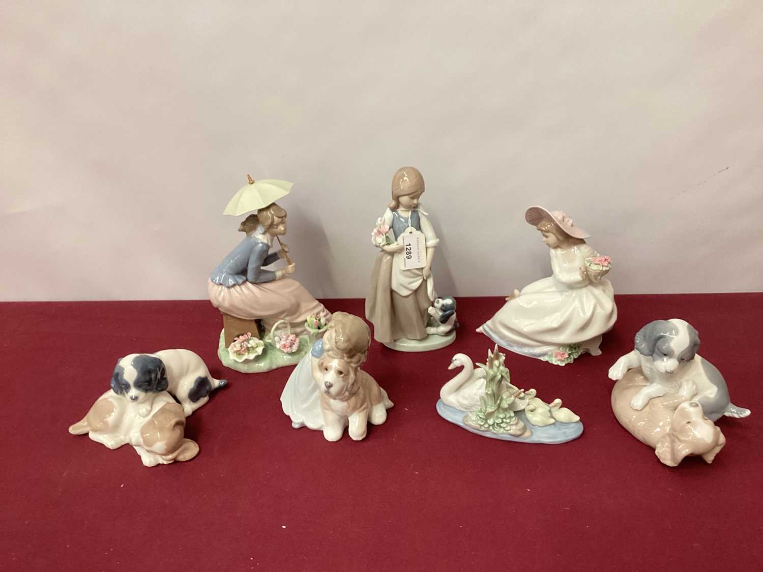 Lot 1289 - Six Nao porcelain figures and dogs, together with a Lladro swan with cygnets (7)