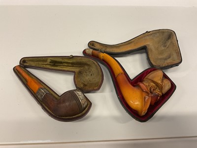 Lot 2565 - Meerschaum pipe carved with the head of Napoleon, and another pipe with silver collar, both with amber stems