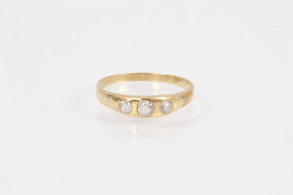 Lot 1069 - Diamond ring set with three old cut diamonds in rub over setting