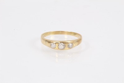 Lot 1069 - Diamond ring set with three old cut diamonds in rub over setting