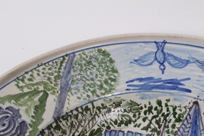 Lot 72 - An unusual tin glazed earthenware dish, painted with a castle and inscribed 'Schloss Bonnarsee (?) in jahre 1805, G. Krank (?)', fruit, flowers and birds around the outside, 36cm diameter