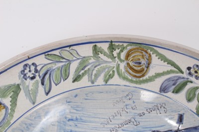 Lot 72 - An unusual tin glazed earthenware dish, painted with a castle and inscribed 'Schloss Bonnarsee (?) in jahre 1805, G. Krank (?)', fruit, flowers and birds around the outside, 36cm diameter