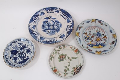 Lot 74 - Four 18th century tin glazed ceramic dishes, including two blue and white and two polychrome, the largest measuring 36cm diameter