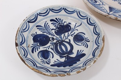 Lot 74 - Four 18th century tin glazed ceramic dishes, including two blue and white and two polychrome, the largest measuring 36cm diameter