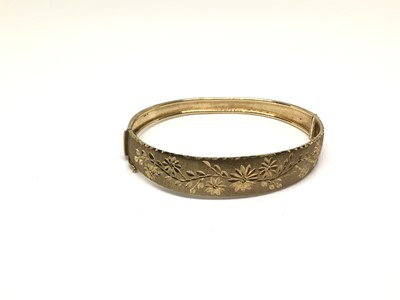 Lot 200 - Italian 9ct gold hinged bangle with engraved floral decoration