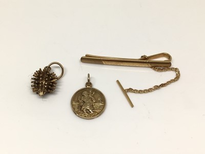 Lot 202 - 9ct gold tie slide, 9ct gold St Christopher pendant and 9ct gold hedgehog charm (3)