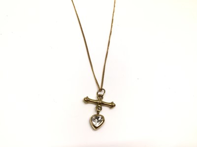 Lot 204 - Yellow metal T-bar and synthetic white heart shaped stone pendant on 9ct gold chain