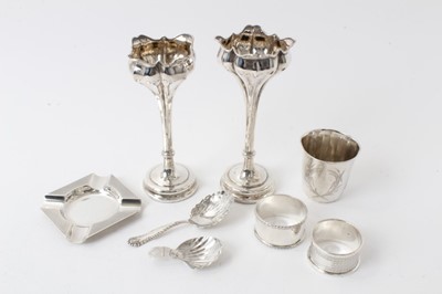Lot 223 - Pair Edwardian silver Art Nouveau spill vases, marks rubbed, 15.5-16cm, two silver caddy spoons, two silver napkin rings, silver beaker and ashtray (8)