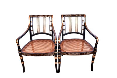 Lot 1359 - Pair of Regency style ebonised and gilt heightened open armchairs, each with Greek key top and seat rails, caned seat on splayed ring turned legs