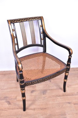 Lot 1359 - Pair of Regency style ebonised and gilt heightened open armchairs, each with Greek key top and seat rails, caned seat on splayed ring turned legs