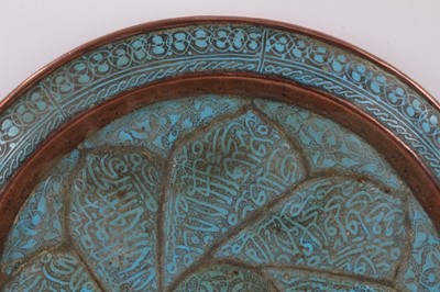 Lot 759 - Antique Islamic copper and enamelled dish, moulded with flower head, with script and arabesque ornament, 30cm diameter