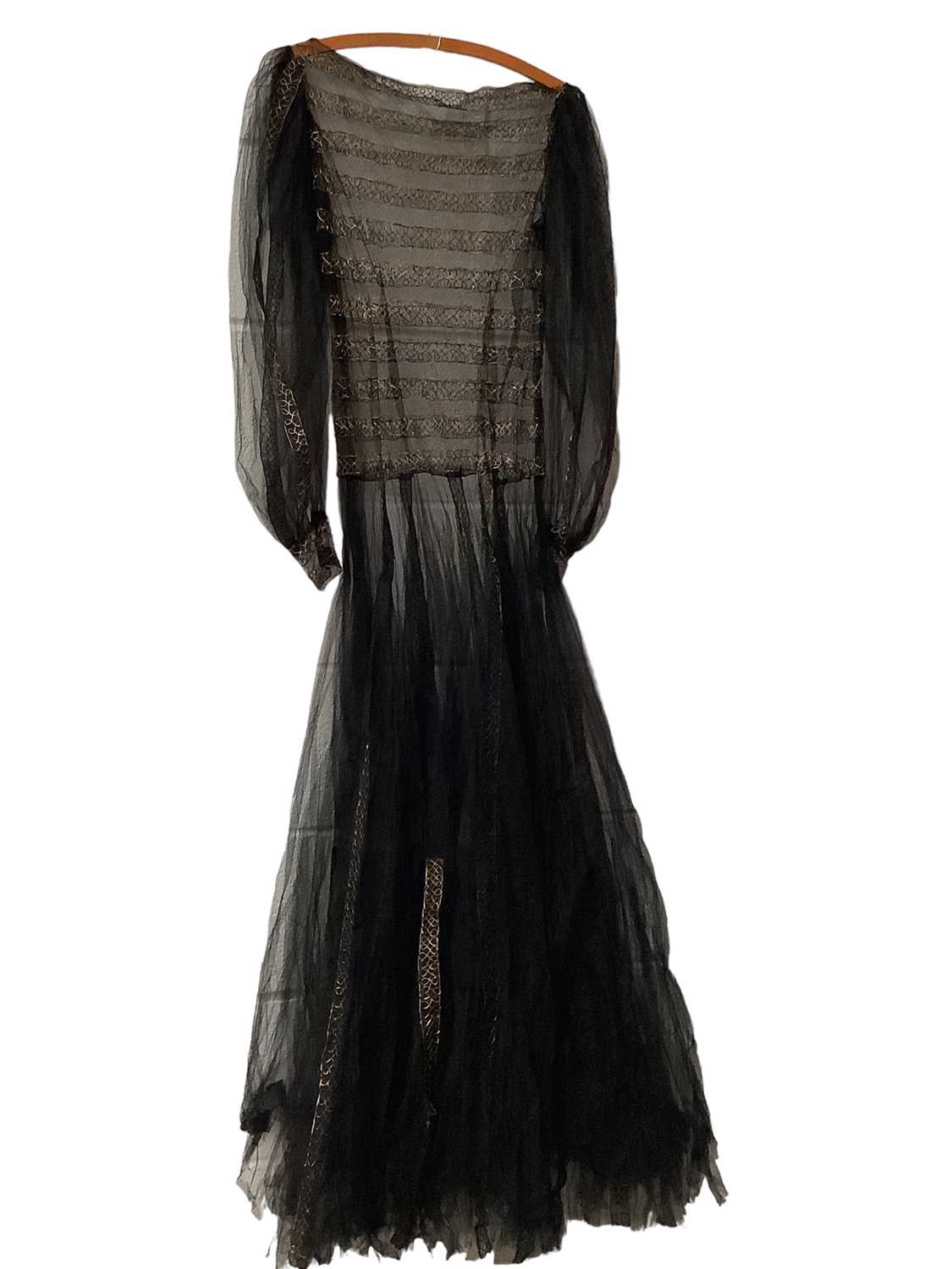 Lot 2052 - Black tulle net evening dress with metallic thread continuous figure of eight embroidery in bands, wide gathered sleeves with narrow cuffs, voluminous gathered skirt. Plus a white layered tulle net...