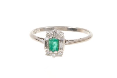 Lot 401 - Art Deco emerald and diamond ring with a rectangular step cut emerald flanked by six single cut diamonds and two baguette cut diamonds to the shoulders on 18ct white gold shank. Ring size P.
