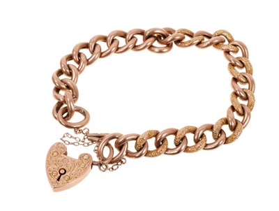 Lot 403 - Edwardian 9ct rose gold curb link bracelet with alternating engraved and polished links with an engraved heart-shaped padlock clasp (Chester 1906). Approximately 19cm.