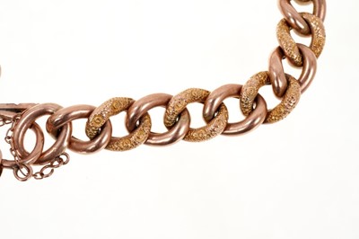 Lot 403 - Edwardian 9ct rose gold curb link bracelet with alternating engraved and polished links with an engraved heart-shaped padlock clasp (Chester 1906). Approximately 19cm.